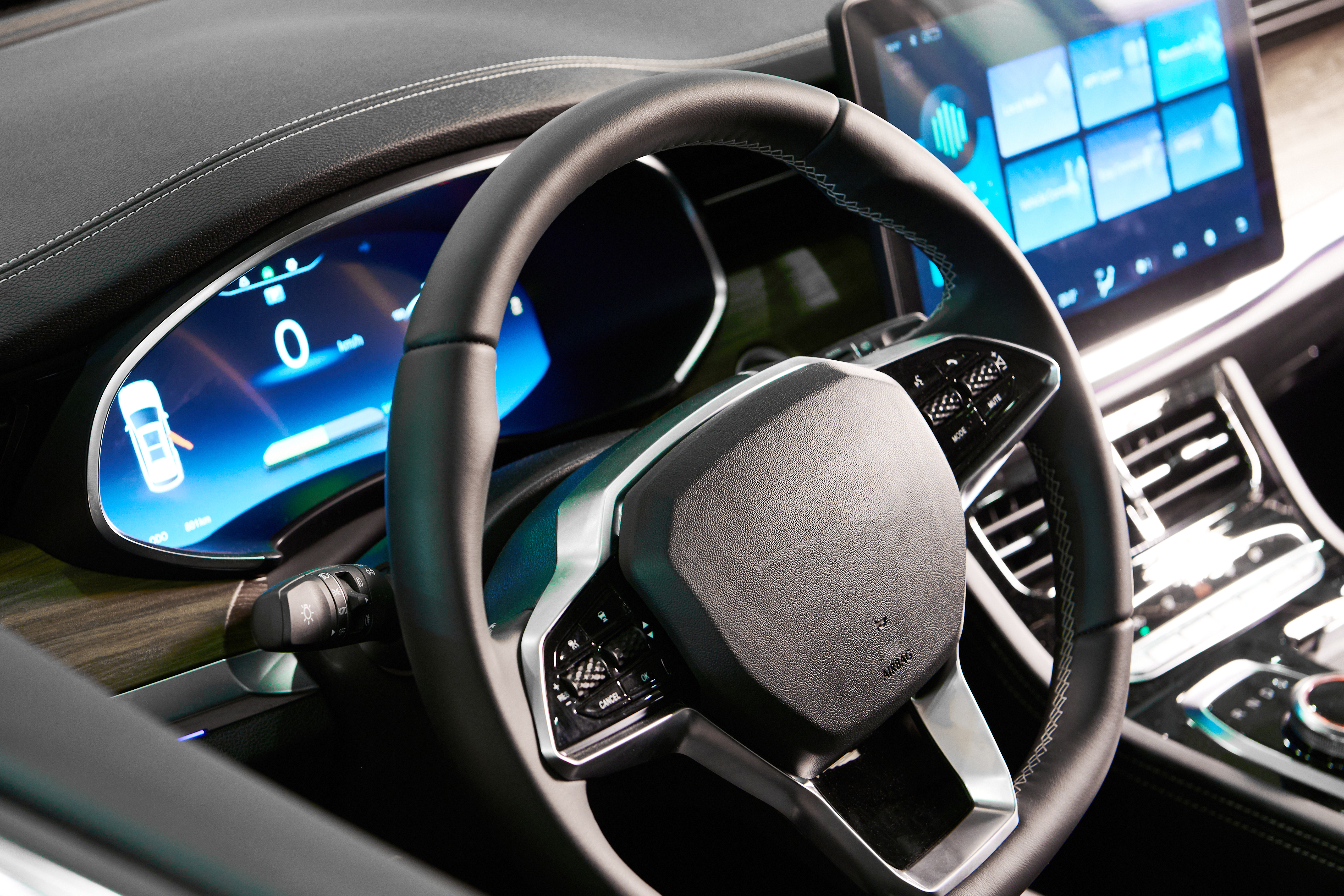 Modern vehicle dashboard with a digital instrument cluster and a large touchscreen beside the leather steering wheel