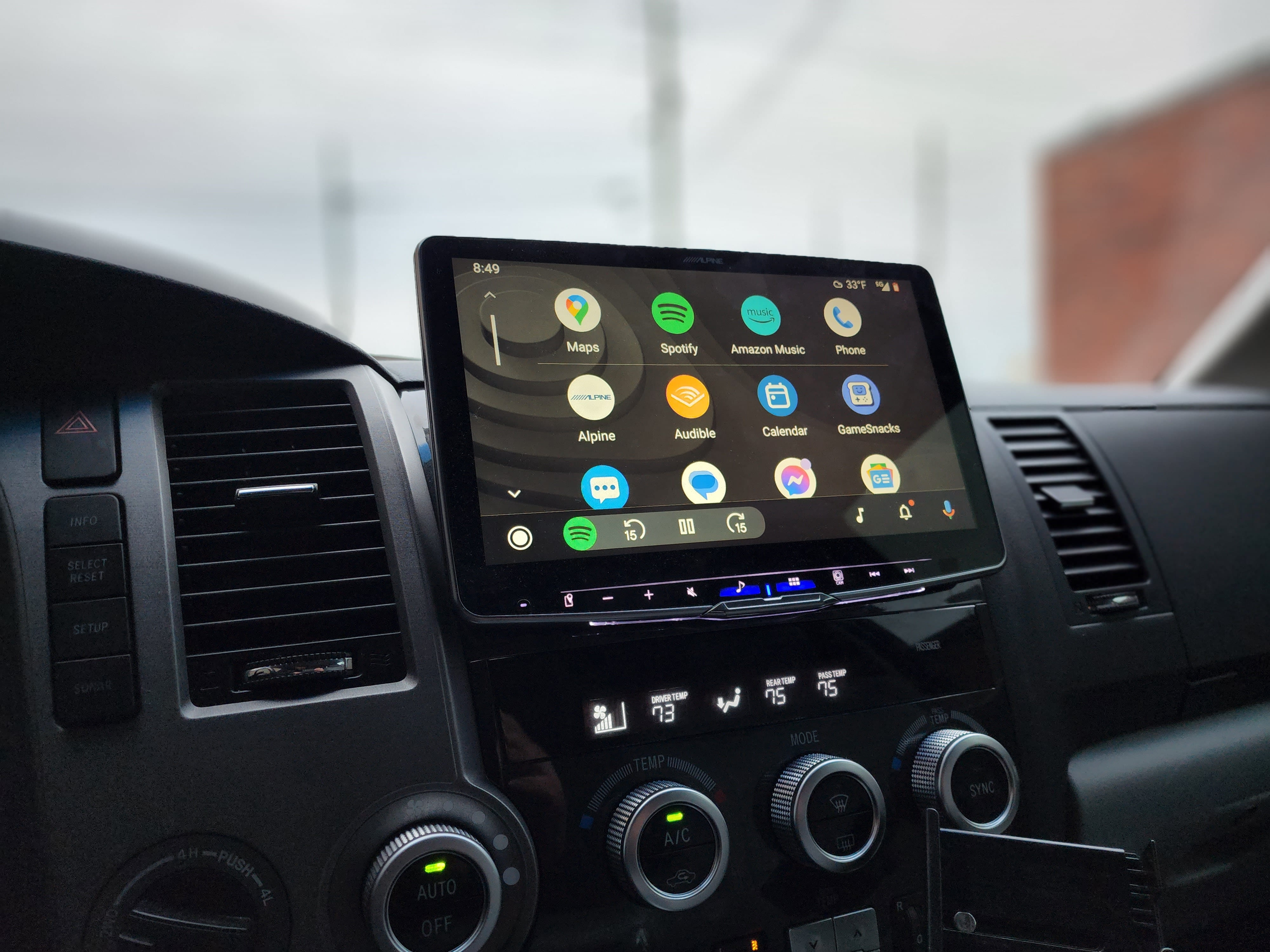Large floating touchscreen radio in a truck dash showing a phone projection app menu.